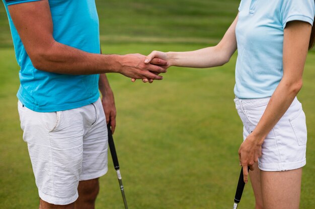 Jugadores de golf de primer plano estrechándole la mano