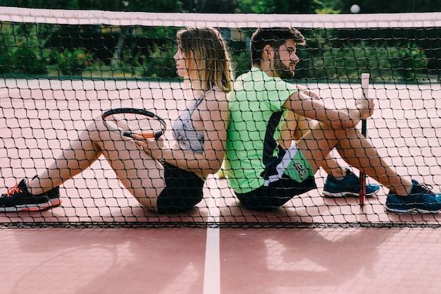 Jugadores de tenis apoyados uno contra el otro