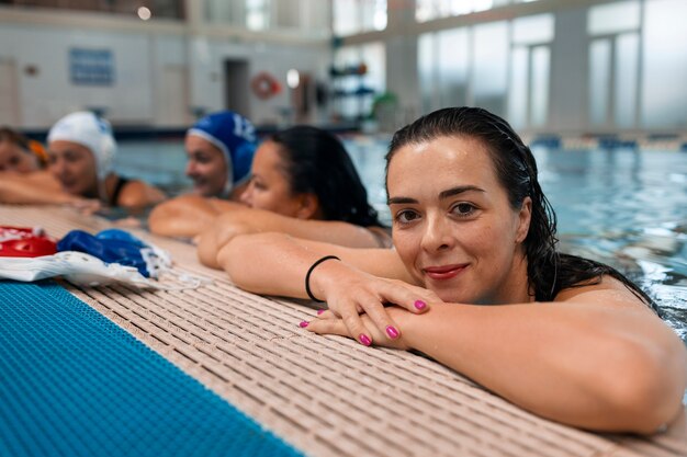 Jugadores de waterpolo en la piscina con equipo de natación.