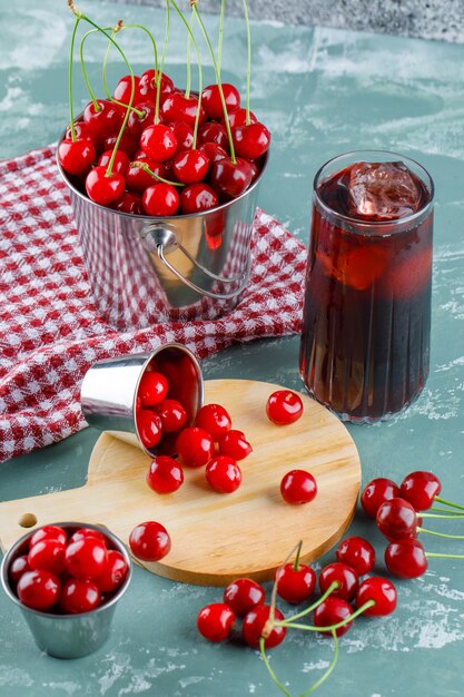 Jugo con cerezas, tabla de cortar, papel de cocina en una jarra,