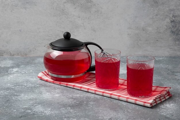 Jugo de cornelas rojas en la tetera y en el vaso.