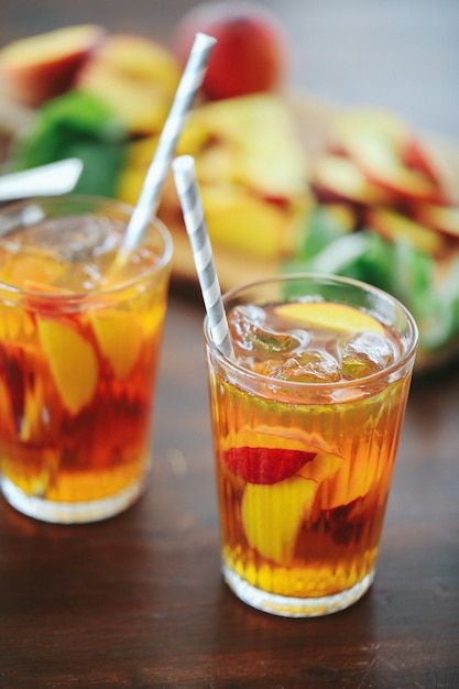 Foto gratuita jugo de durazno en tazas con rodajas de fruta dentro