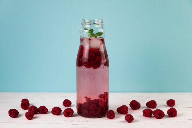 Jugo de frambuesa helado fresco con fondo azul claro