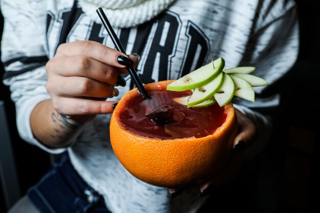 Jugo de fruta fresca servido en piel de naranja