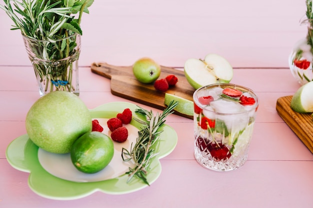 Jugo hecho en casa con ingrediente en el fondo rosado de madera