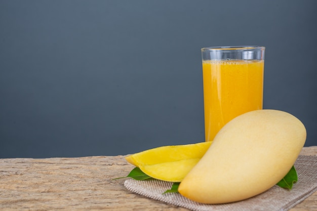 Foto gratuita jugo de mango en la mesa del piso de madera.