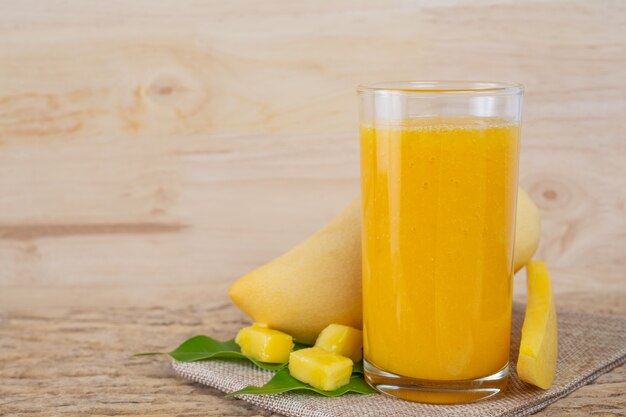 Jugo de mango en la mesa del piso de madera.