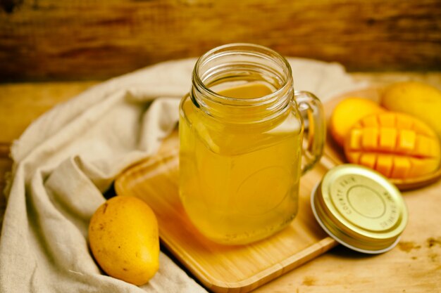 Jugo de mango en el vaso de la mesa de madera