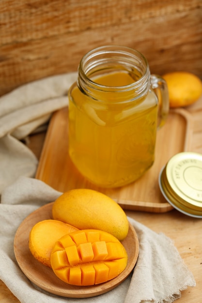 Jugo de mango en el vaso de la mesa de madera