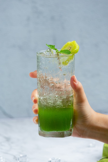 Jugo de manzana fresco en un vaso con manzanas verdes.