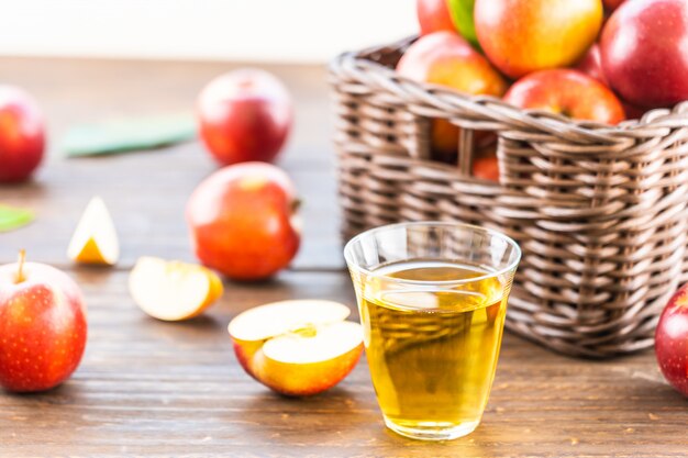 Jugo de manzanas en vaso con manzana en la cesta