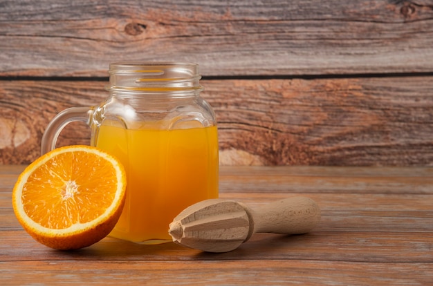 Jugo de naranja en un frasco de vidrio sobre la mesa de madera