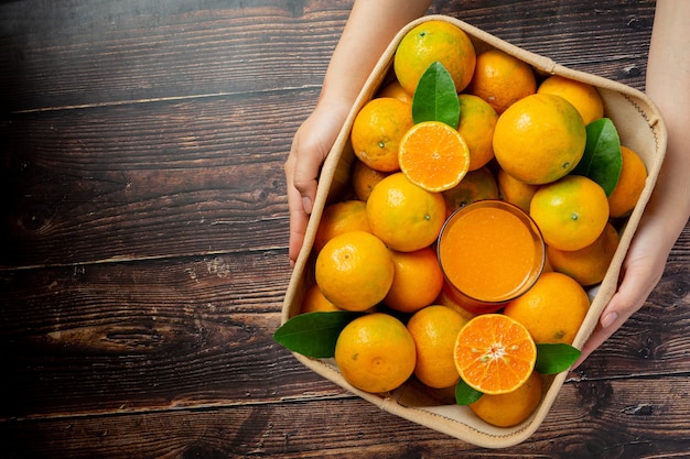 Jugo de naranja fresco en el vaso sobre fondo de madera oscura.