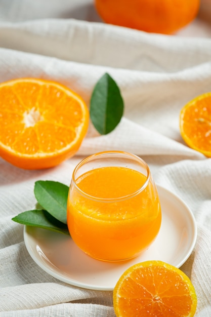 Jugo de naranja fresco en el vaso sobre fondo de mármol