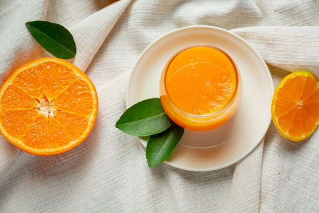 Jugo de naranja fresco en el vaso sobre fondo de mármol