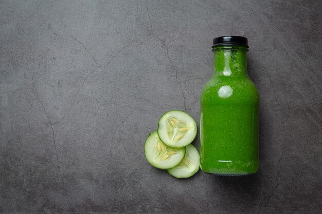 Jugo de pepino fresco en un frasco sobre fondo oscuro