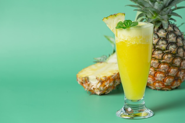 Jugo de piña en superficie verde