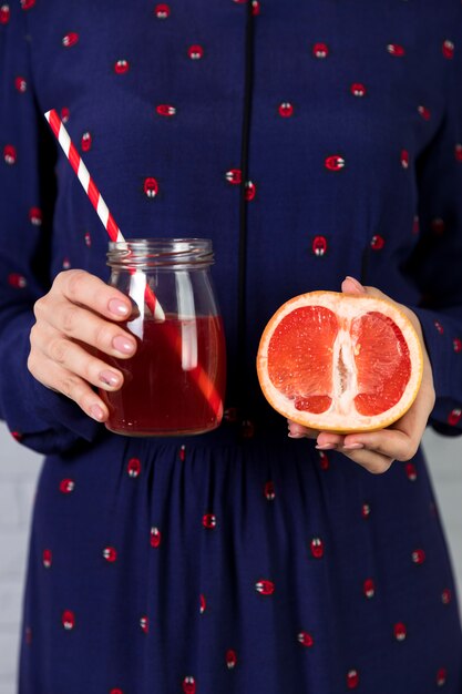 Jugo de pomelo fresco hecho en casa y un pomelo en rodajas