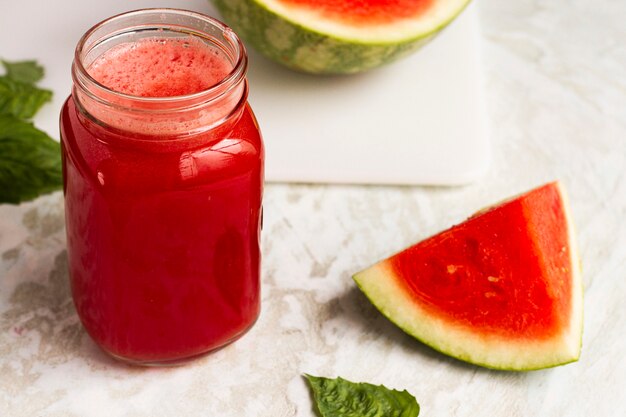 Jugo de sandía de alto ángulo en frasco de vidrio