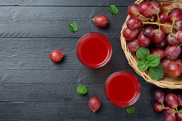 Jugo de uva fresco en la superficie de madera oscura.