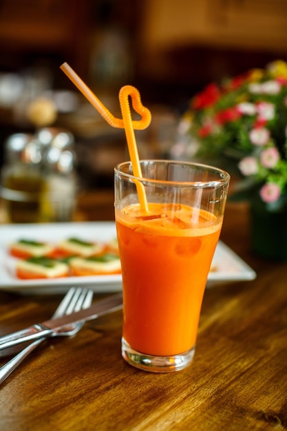 Jugo de zanahoria fresco y lechuga en una mesa de madera