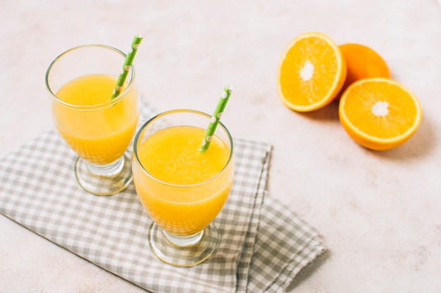 Foto gratuita jugos de naranja frescos de alto ángulo en toalla