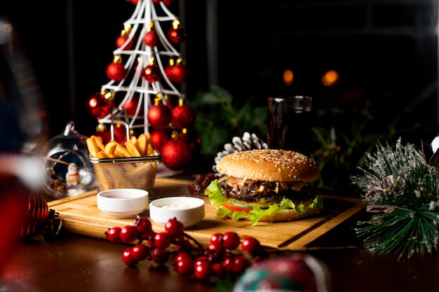 Jugosa hamburguesa con papas fritas en una tabla de madera