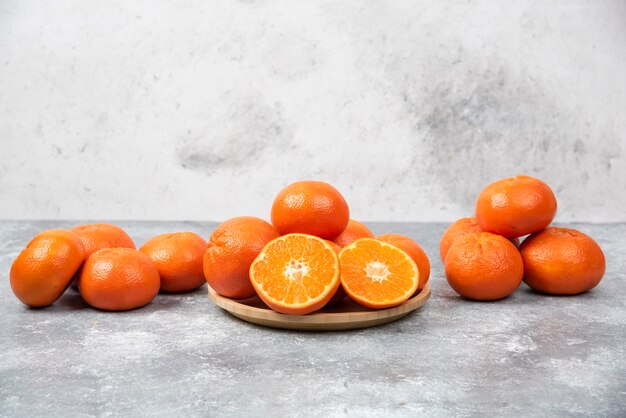 Jugosas frutas de color naranja con rodajas en la mesa de piedra.