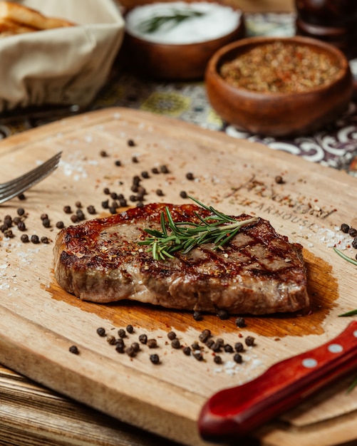 Foto gratuita jugoso bistec con romero y pimienta negra