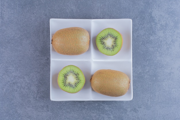 Foto gratuita jugosos kiwis en una mesa de mármol plateon.