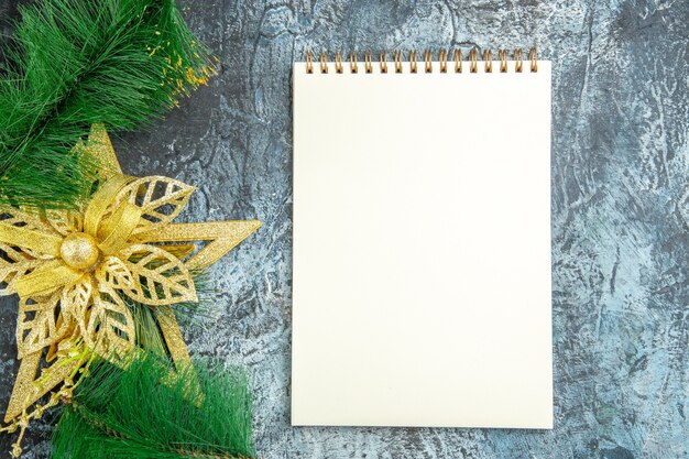 Juguete del árbol de Navidad de la vista superior un cuaderno en la superficie gris