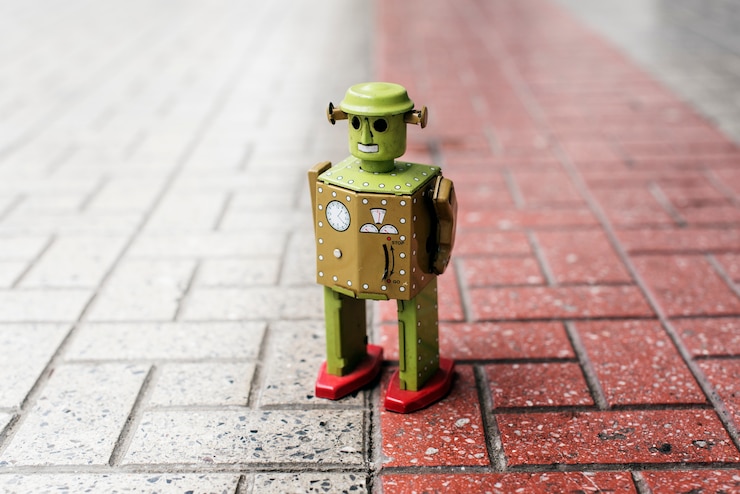 Foto gratuito juguete de robot estaño retro parado en el suelo con el patrón