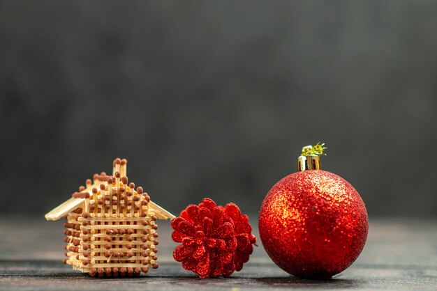 Los juguetes del árbol de Navidad de la vista frontal coinciden con la casa en el espacio libre oscuro