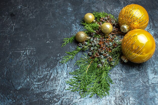 Juguetes de árbol de Navidad de vista frontal con rama verde sobre fondo claro-oscuro