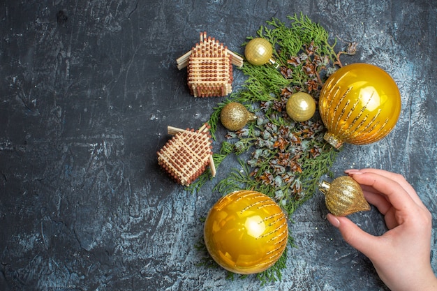 Juguetes de árbol de Navidad de vista superior con rama verde sobre fondo claro-oscuro