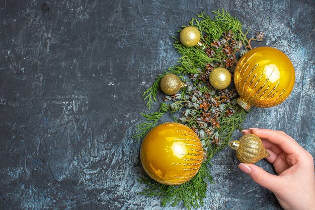 Juguetes de árbol de Navidad de vista superior con rama verde sobre fondo claro-oscuro