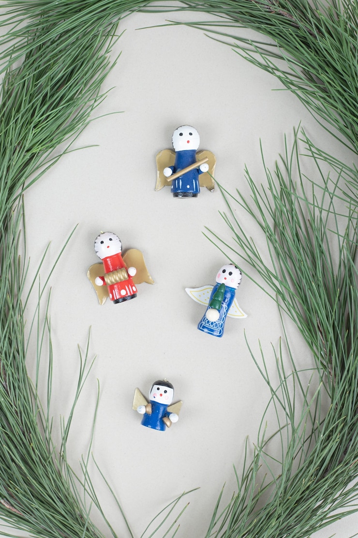 Foto gratuito juguetes navideños y rama en superficie beige.