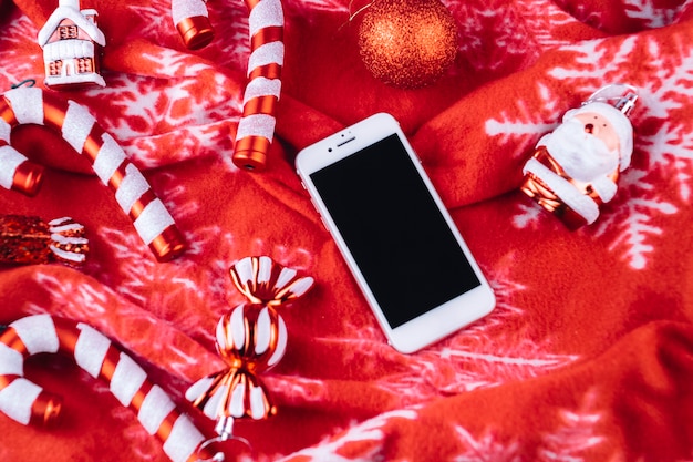 Juguetes navideños con smartphone en manta.