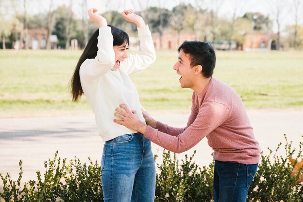 Juguetón joven cosquillas mujer