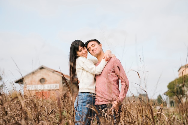 Juguetón pareja joven de pie abrazos