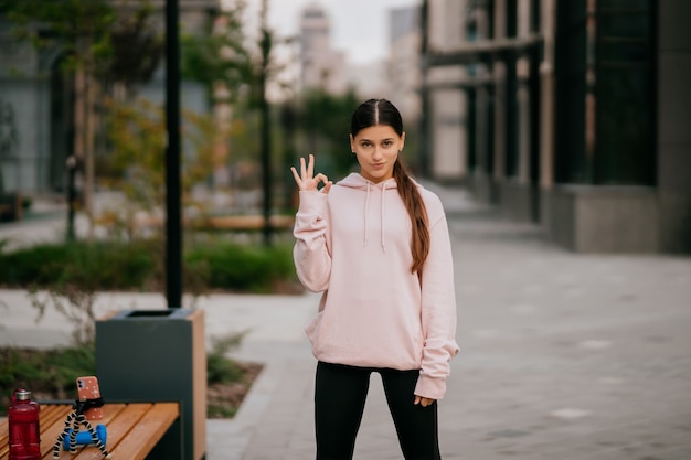 Juguetón retrato de mujer joven y bonita divirtiéndose en la calle