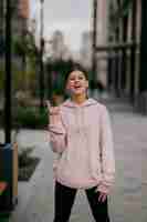 Foto gratuita juguetón retrato de mujer joven y bonita divirtiéndose en la calle