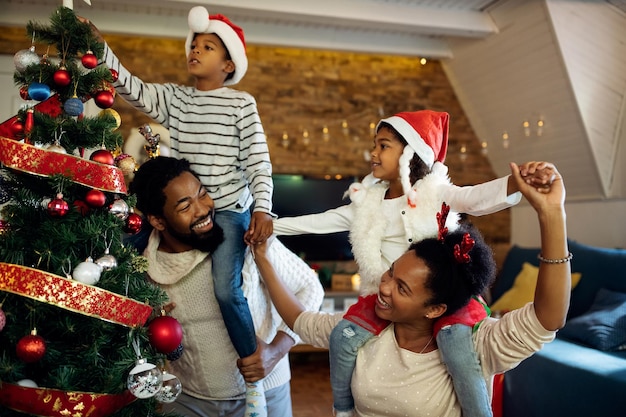 Juguetona familia afroamericana divirtiéndose el día de Navidad en casa