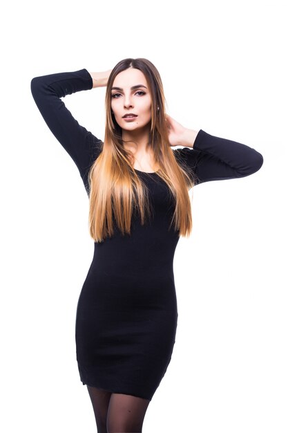 Juguetona mujer divertida de pie en vestido negro sobre blanco