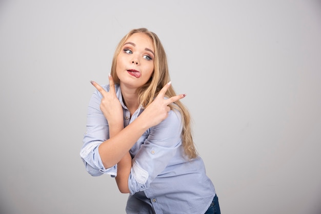 Juguetona mujer rubia sacando la lengua