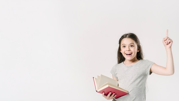 Foto gratuita junior parado con el libro emocionado