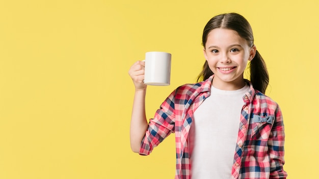 Foto gratuita junior sosteniendo la copa en el estudio