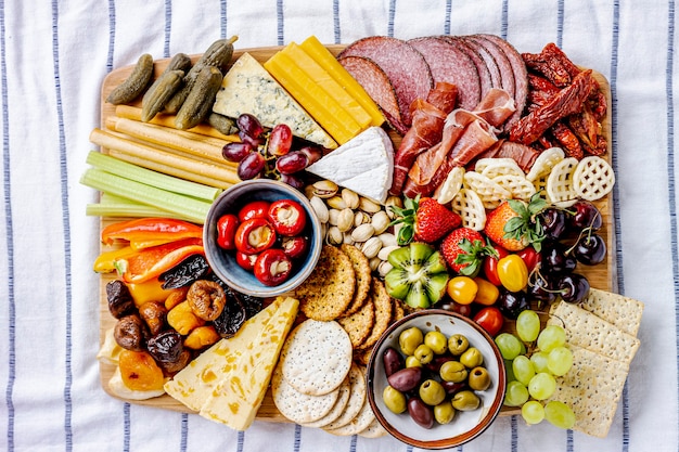 Junta de charcutería con embutidos, frutas frescas y queso de cerca