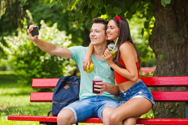 Junte sostener la comida sana que toma el autorretrato en el parque