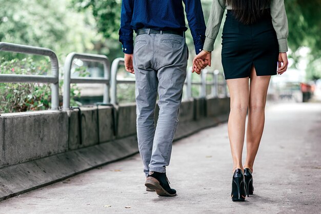 Juntos. Toma recortada de hermosa pareja bien vestida, caminando al aire libre. Amor, relación, concepto de citas. Vista trasera